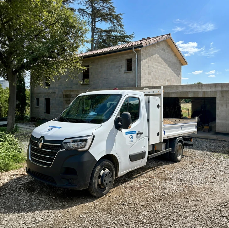 Deux hommes en chemises à carreaux examinent des plans architecturaux en extérieur
