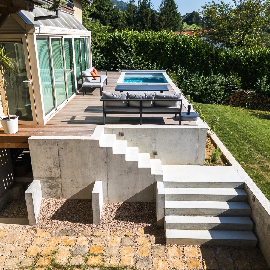 Maison contemporaine plain-pied à parement en pierre dorée irrégulière, toiture à faible pente avec débord en bardage métallique brun