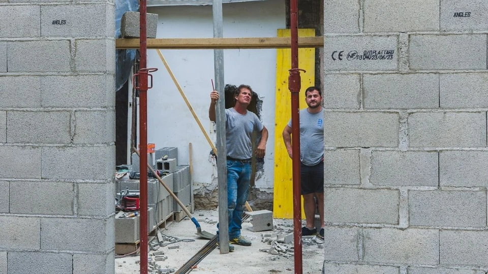 Structure métallique en cours de construction avec assemblage de poutres en acier galvanisé et colonnes verticales contre ciel bleu dégagé