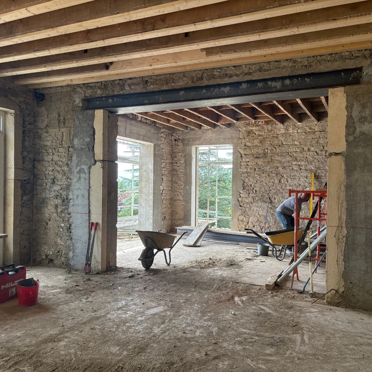 Ouvrier en restauration de bâtiment historique travaillant sur façade en briques rouges anciennes