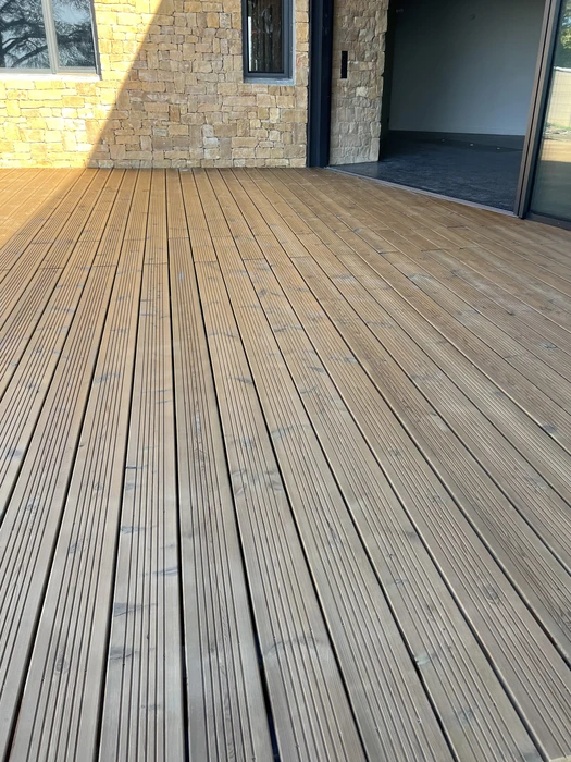 Terrasse extérieure en bois massif, poses en lames parallèles avec rainures antidérapantes