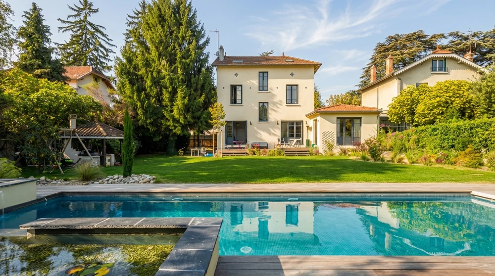 Propriété résidentielle bourgeoise avec piscine rectangulaire à débordement, plage en bois composite et margelles en pierre bleue